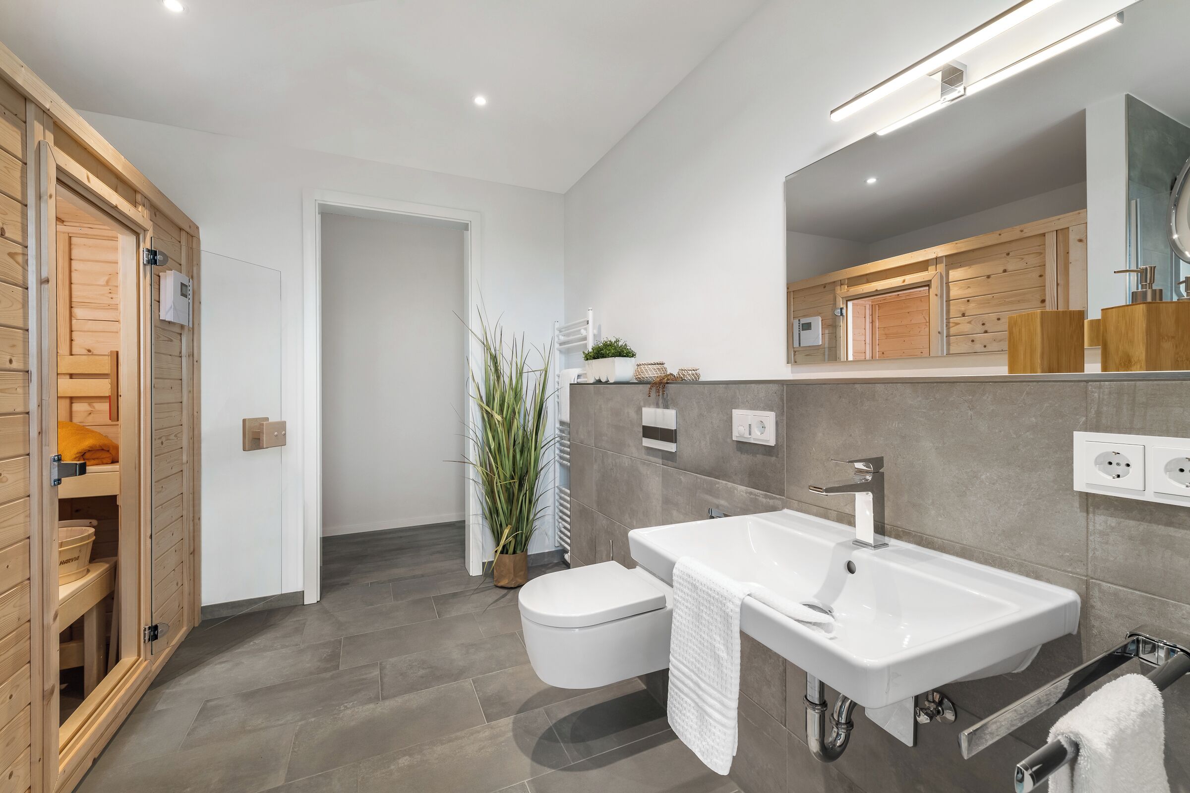 Une salle de bain moderne avec un lavabo blanc, des toilettes et un meuble en bois.