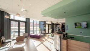 A modern reception area with a reception desk, seating area, and large windows.
