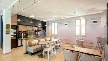 Un café moderne doté d’un espace cuisine, de différents types de sièges et d’un intérieur propre et bien éclairé.