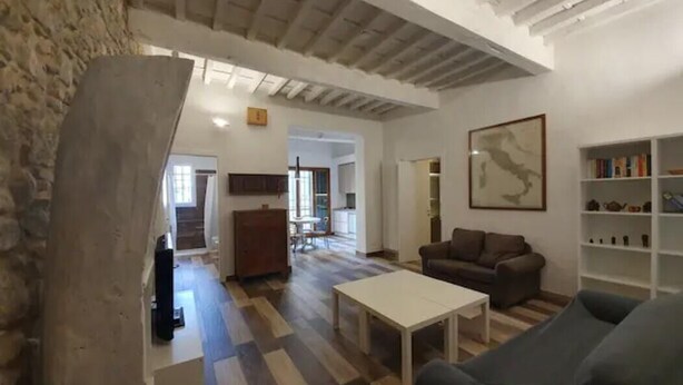 A spacious living area with a wooden floor, a white coffee table, a sofa, and a bookshelf. - Zanobi 66 - Two Bedroom Apartment, Sleeps 4 (Firenze)