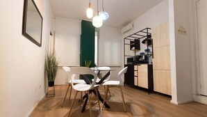A modern kitchen with a black countertop, white cabinets, and a hanging pot rack. - Regina House in the center of Cagliari (Cagliari)