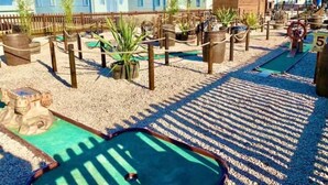 A miniature golf course with sand traps, a green putting area, and a wooden structure. - Lodge - Sleeps 8 - Parking, Wifi, (Clacton-on-Sea)