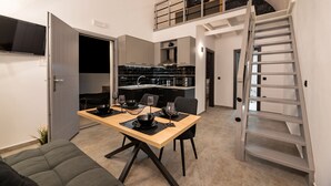 Eine moderne Küche mit Essbereich, Treppe und Fernseher.