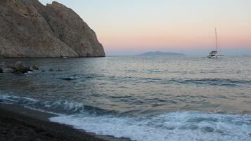 On the beach, black sand, beach towels