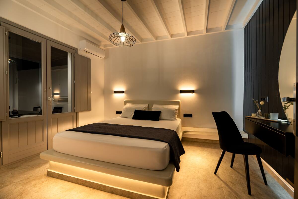 Une chambre moderne avec un grand lit, des tables de chevet, un bureau et une chaise.