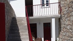 A two-story house with a staircase leading to a balcony.