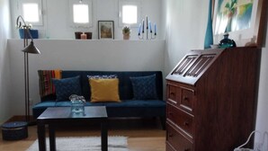 A living room with a sofa, coffee table, wooden cabinet, and a striped rug.