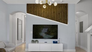 Un salon moderne avec un grand téléviseur à écran plat fixé à un mur blanc, un motif de lattes en bois au-dessus du téléviseur, une console blanche en dessous et un tapis à motifs sur le sol.