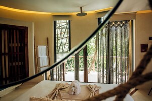 Une chambre avec un lit, une fenêtre donnant sur un paysage verdoyant et une porte en bois.