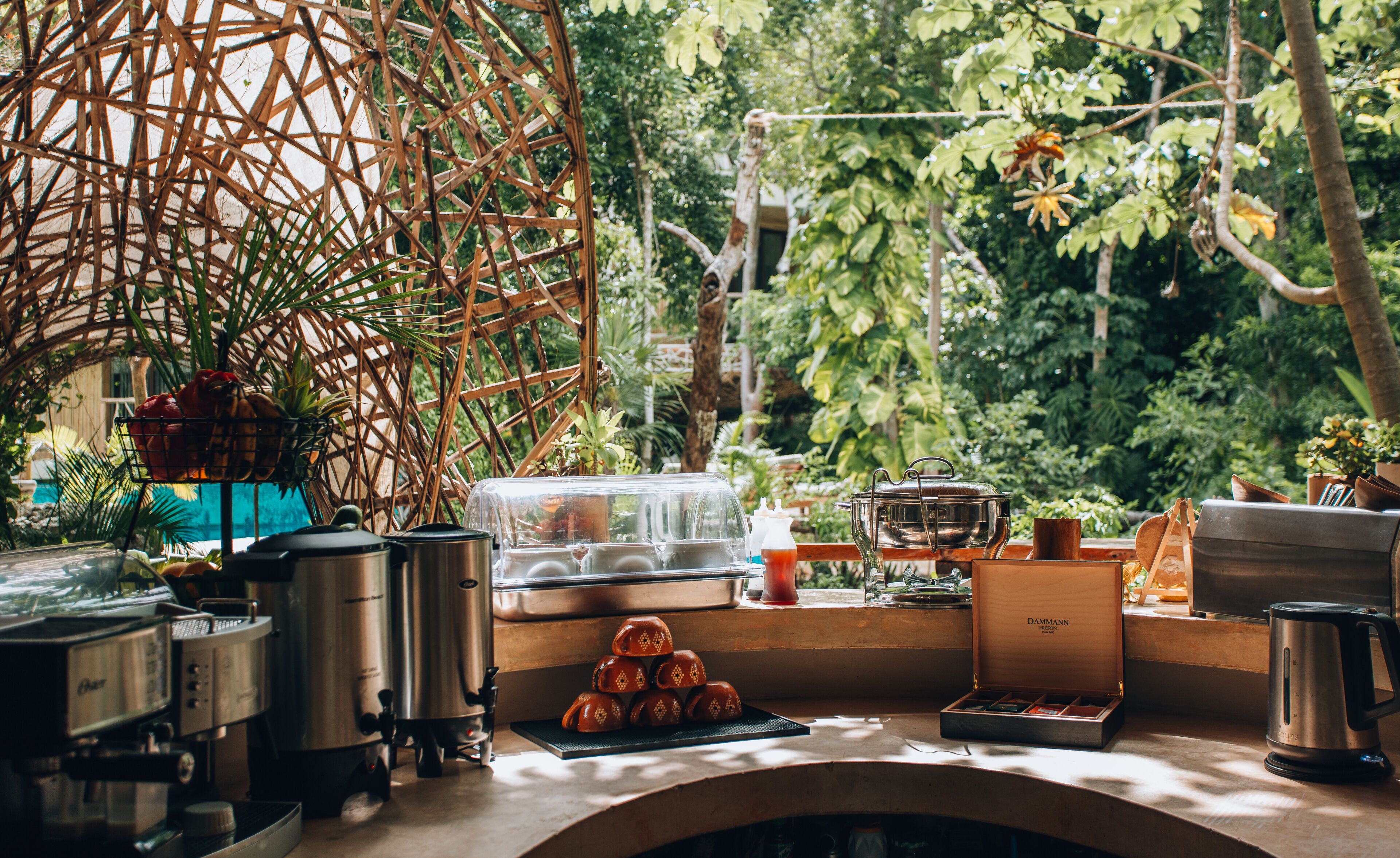 A kitchen area with various cooking appliances, a coffee machine, and a wooden structure in the background.
