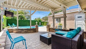 A covered patio with outdoor furniture, a pool, and a view of the backyard. - Perfect Oasis w/ Pool, jacuzzi, close to airports, beach, entertainment & more! (Long Beach)