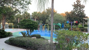 A playground with colorful slides and a water feature. - Bahama Bay Community, Pools, Basketball, Natural Trails and More! (Davenport)