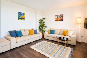 A living room with two sofas, a coffee table, a lamp, and two paintings on the wall.