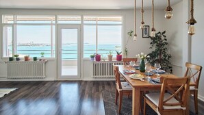 A dining area with a view of the sea, wooden flooring, and potted plants. - A MILLION DOLLAR VIEW IN THE HEART OF ISTANBUL (İstanbul)