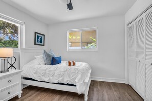 A bedroom with a bed, a nightstand, a window, and a closet. - Private Heated Pool · Sleeps 8 · Pets Welcome · Boca Raton (Boca Raton)