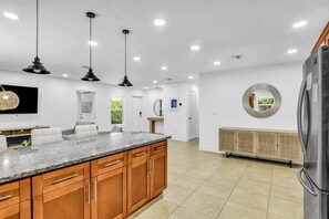 A modern kitchen with granite countertops, wooden cabinets, and stainless steel appliances.