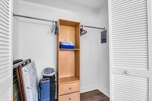 A walk-in closet with a wooden wardrobe, a hanging rod, and a small shelf. - Private Heated Pool · Sleeps 8 · Pets Welcome · Boca Raton (Boca Raton)