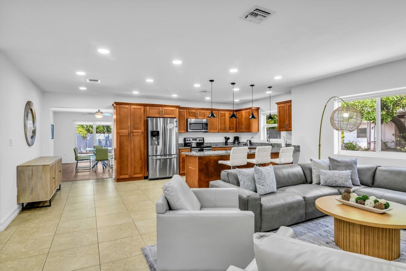 A modern kitchen with stainless steel appliances, wooden cabinets, and pendant lighting.