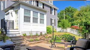 A house with a patio area featuring outdoor furniture and a fire pit. - Charming 3-Bedroom Home Near Downtown Portsmouth! (Kittery)