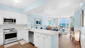 A modern kitchen with white cabinets, stainless steel appliances, and a large island. - 🌊Gulf Views~FREE Beach Svc~Kayak/SUP2~Pools+Splash Pad~BeachFRONT~3BR Azure 407 (Ft. Walton Beach)