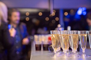 A row of champagne flutes on a bar counter.