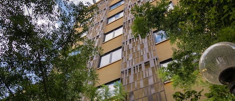 Een hotelgebouw met een modern design, met een opvallende verticale structuur en een bord waarop staat dat het het Dunin Hotel in Athene is.