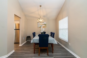 Enjoy meals in this dining area with a table for four, featuring a pendant light and comfortable seating.