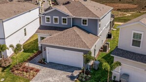 A residential area with detached houses, a garage, and a well-maintained lawn. - Amazing 5/6 Vacation Home at Windsor Island Resort!!! (Davenport)