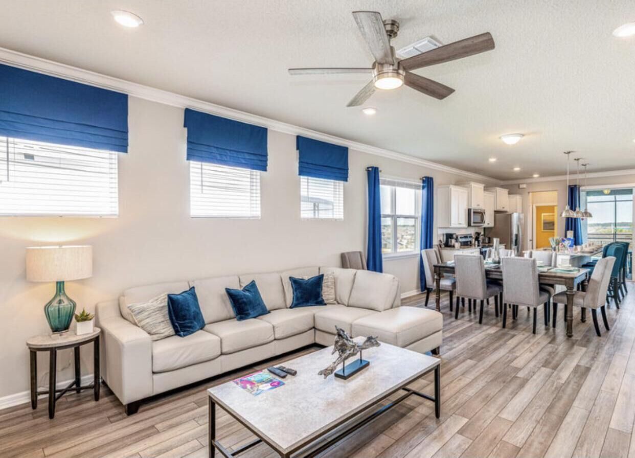 A modern living room with a sofa, coffee table, and dining area.