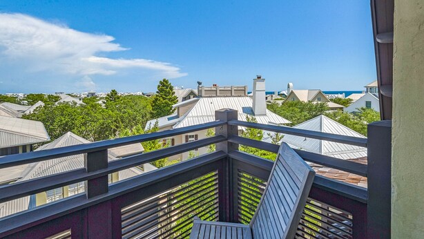 A balcony with a view of neighboring houses and trees.