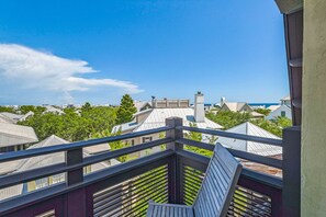 A balcony with a view of neighboring houses and trees. - SeaDreams -Great Condo! Sleeps 6, Views of Rosemary and the Gulf! (Rosemary Beach)