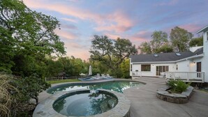 En boligejendom med swimmingpool, spa og en overdækket patio.