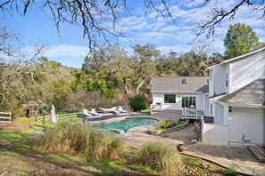 A house with a swimming pool, a deck, and a view of the surrounding trees. - Farmhouse at Sonoma Oaks. Hot Tub, Pool, Bocce! (Santa Rosa)