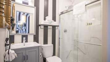 Een bad/douchecombinatie, een haardroger, handdoeken