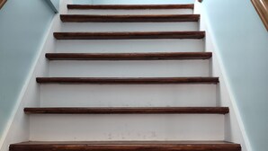 A staircase with wooden steps and white walls. - Harrison Hotel  Unit G2 Pet Friendly  STEEP STAIRS! 3rd story Studio apartment.
 (Garden City)