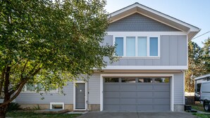A two-story house with a garage, a tree in front, and a driveway. - BOOK 7 NITES AND GET A DISCOUNT 2 BEDROOM PRIVATE UNIT (Portland)