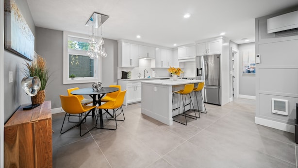 A modern kitchen with white cabinets, a central island, and yellow chairs. - BOOK 7 NITES AND GET A DISCOUNT 2 BEDROOM PRIVATE UNIT (Portland)