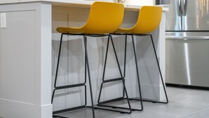 A kitchen with two yellow bar stools, a stainless steel refrigerator, and a white countertop. - BOOK 7 NITES AND GET A DISCOUNT 2 BEDROOM PRIVATE UNIT (Portland)