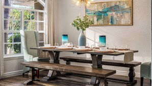 A dining area with a long table set for four, a bench, and a vase with greenery. - Near Downtown &Beach! Games! Private Pool! Hot Tub (Bradenton)