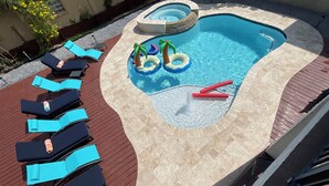 A swimming pool with lounge chairs and inflatable toys. - Heated Pool & Hot Tub!  Fall and Winter SPECIAL! (South Padre Island)