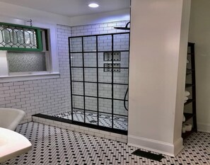 Bathtub, rainfall showerhead, hair dryer, towels