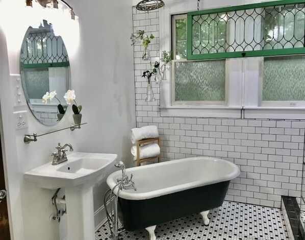 Bathtub, rainfall showerhead, hair dryer, towels