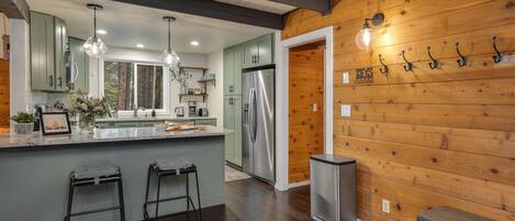 A modern kitchen with a central island, stainless steel appliances, and wooden accents.