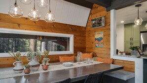 L’intérieur d’un chalet en bois comprend un coin repas, des murs en bois et une grande fenêtre.
