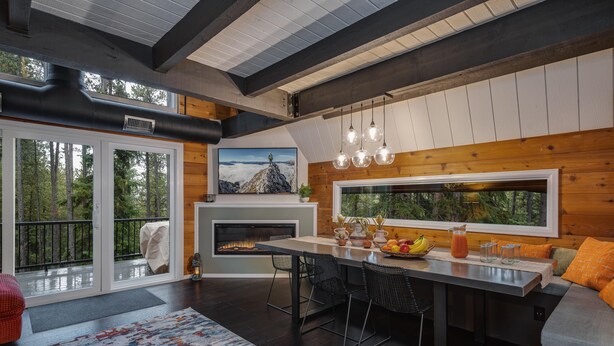 Une cuisine moderne dotée d’un grand îlot central, de touches de bois et d’une cheminée.