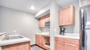 A kitchen with a stainless steel refrigerator, a microwave, and a coffee maker.