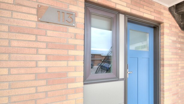 A brick building with a blue door and a window.