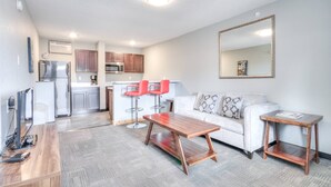 A modern living space with a kitchen, dining area, and seating.