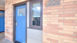 A brick building with a blue door and a window.