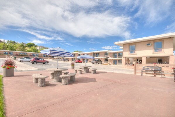 Relax in the hotel's spacious outdoor area with a patio, benches, and shaded seating.